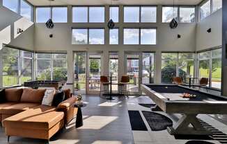 a large living room with a pool table and large windows