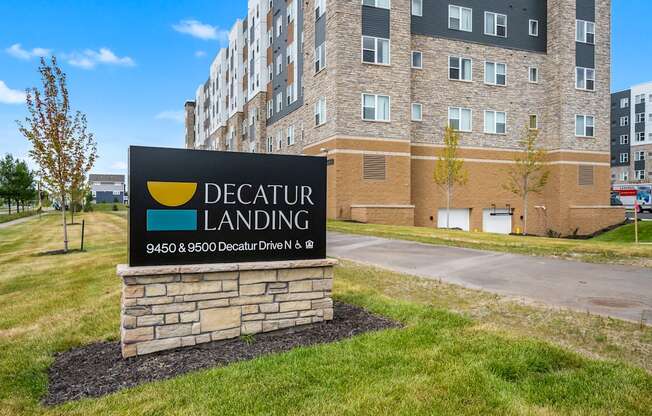 A sign for Decatur Landing in front of a building.