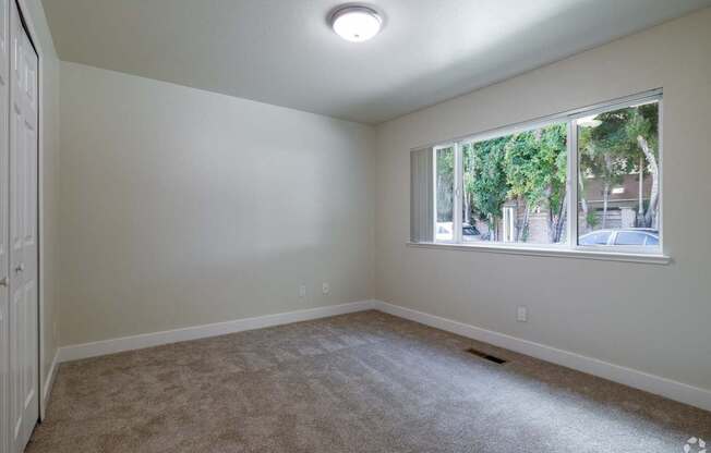 an empty living room with a large window