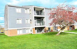 the outlook of an apartment building with a flowering tree