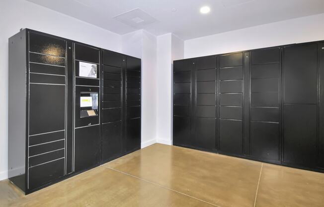 a room with black lockers on the wall and a wooden floor