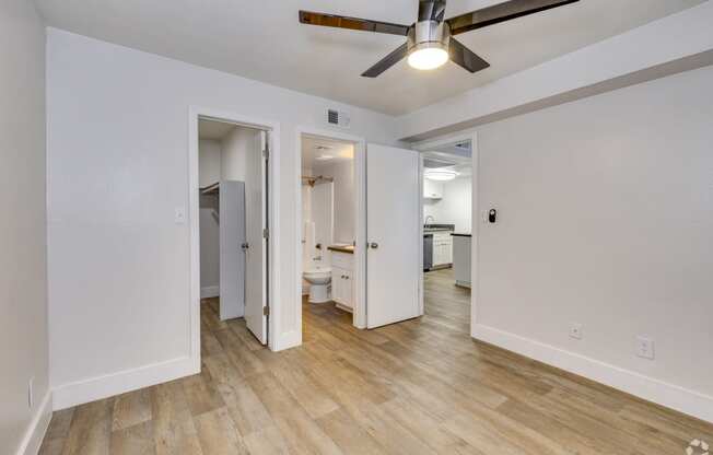 a living room with white walls and a ceiling fan