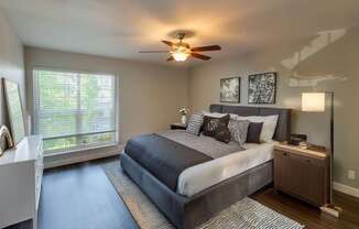 A bedroom with a large bed and a ceiling fan.