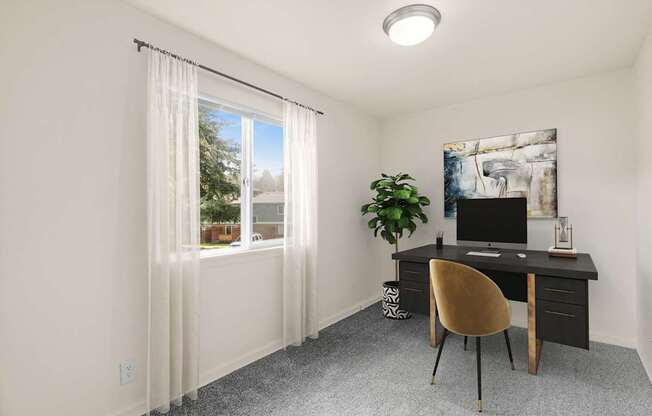 A room with a desk, chair, and a window with curtains.