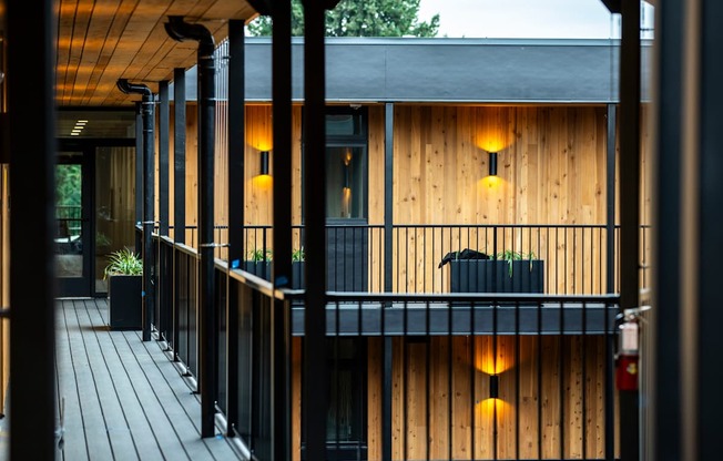 a house with wooden walls and a balcony with lights on it