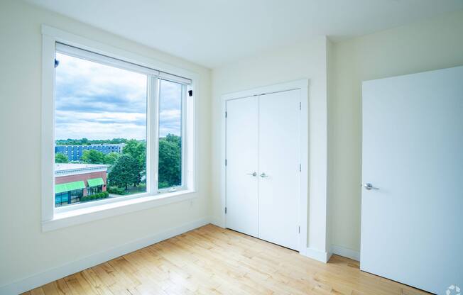 A room with a large window overlooking a cityscape at 603 Concord Apartments, Massachusetts