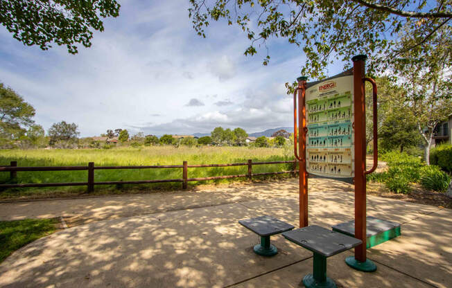 a bench and a sign next to a field