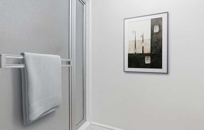 A white towel hangs on a silver towel rack.