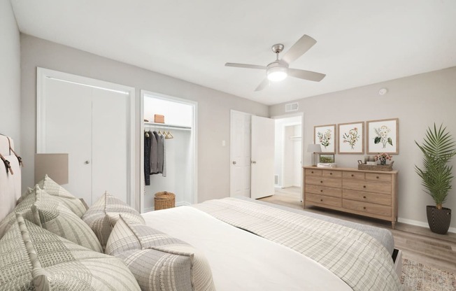 a bedroom with a large bed and a ceiling fan