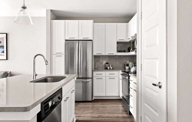 A kitchen with white cabinets and appliances.