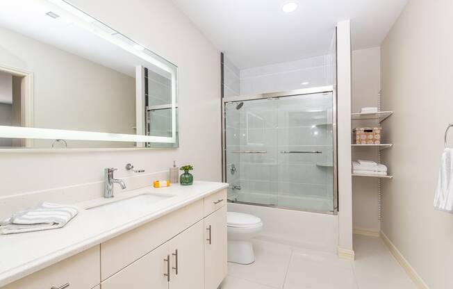 The sto bathroom with granite flooring, glass shower door, and high quality finishes