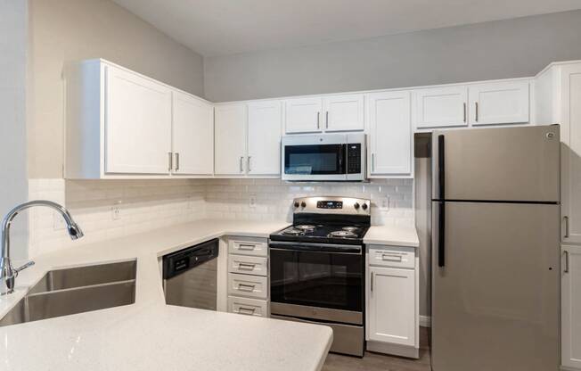 Kitchen with Whit Cabinets and Counters with Stainless Steel Appliances