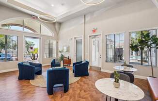 A spacious room with blue chairs and a white table.
