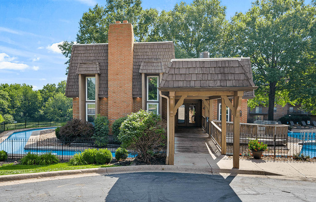 a building with a covered porch next to a swimming pool