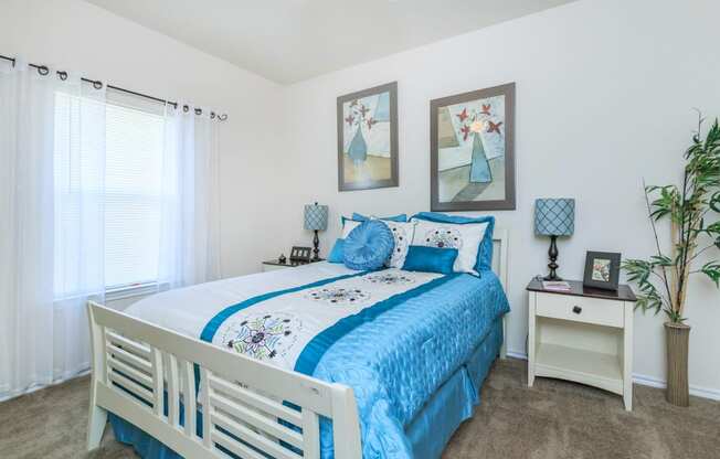 a bedroom with a white bed and blue comforter