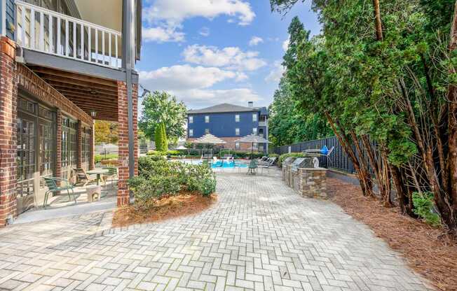 A brick patio leads to a pool area.