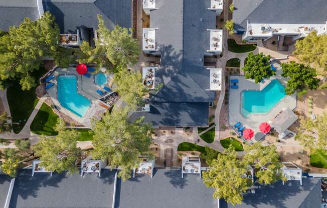 a birds eye view of the resort with pools and trees