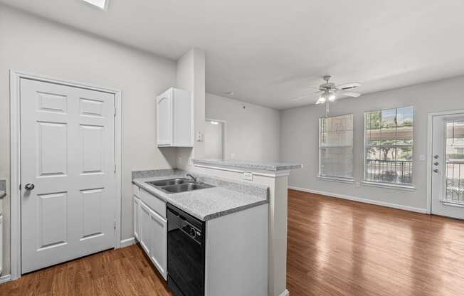 a kitchen with an island and a door to a living room