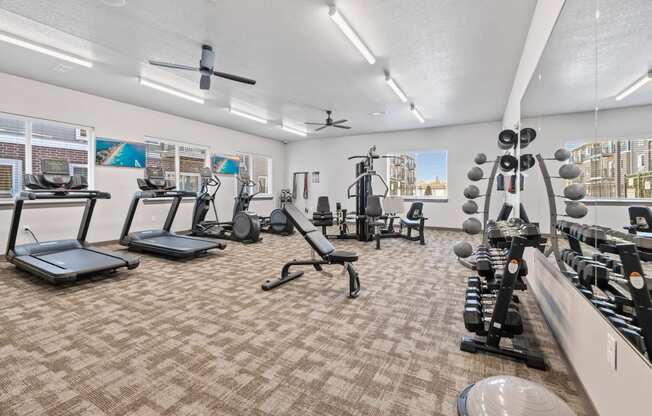 Modern gym with rows of cardio equipment.