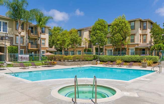 A swimming pool in front of apartment buildings.