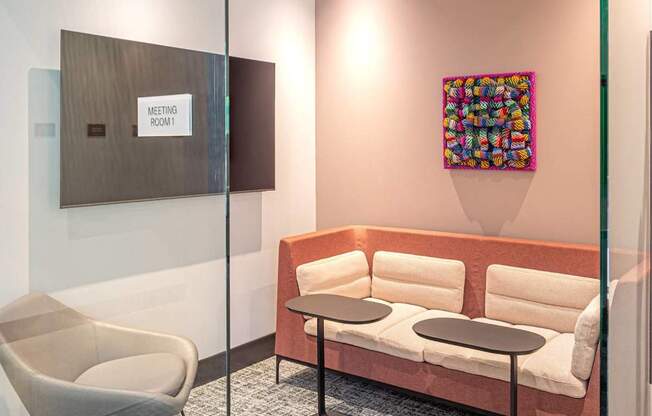A glass wall separates a meeting room from a hallway.