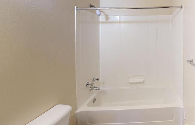 A bathroom with a toilet, tub, and shower at Glen Oaks Apartments, Michigan, 49442