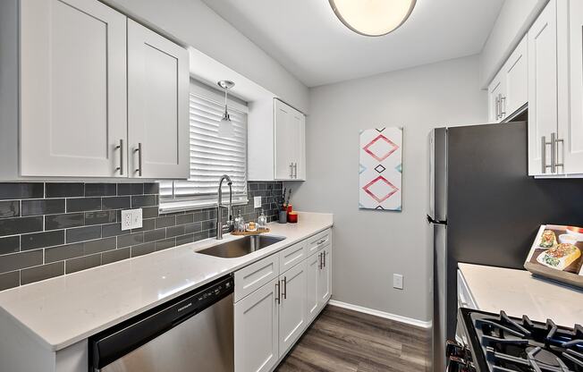 a kitchen with white cabinets and a stainless steel refrigerator