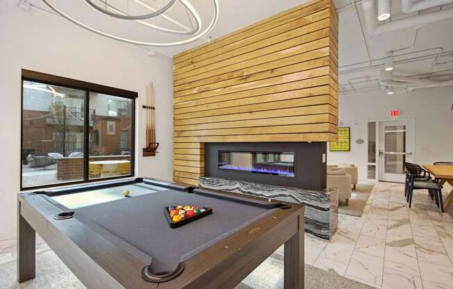 clubhouse with pool table and fireplace at the district at highland village apartments at Link Apartments® Calyx, North Carolina, 27517