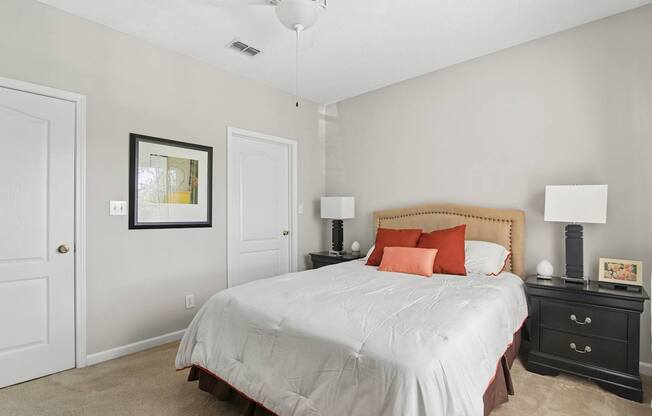 A bedroom with a bed, nightstand, and lamp.