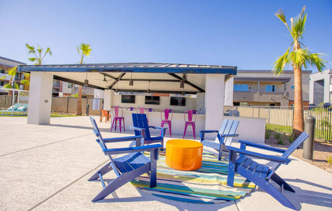 a patio with blue chairs and a table and a canopy