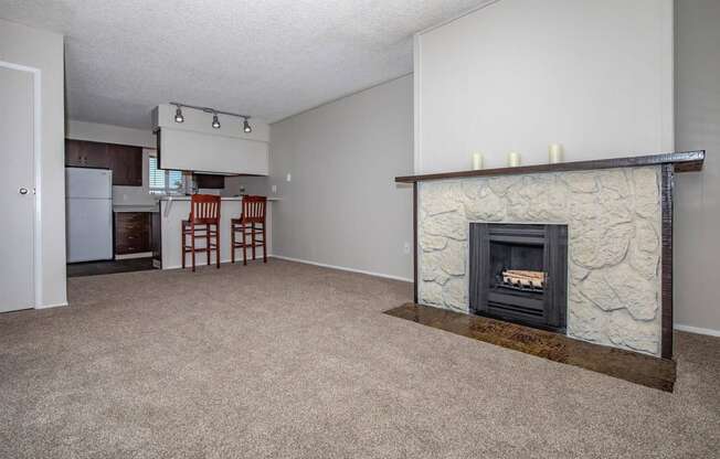 a living room with a fireplace and a kitchen in the background at Lincoln Village Apartments, Spokane, WA 99208