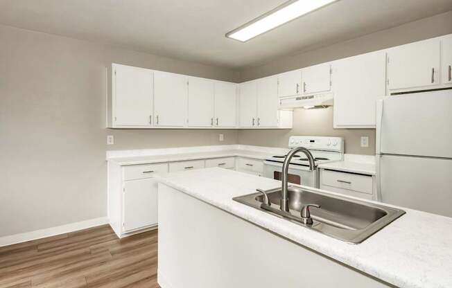 A kitchen with white cabinets and a sink.