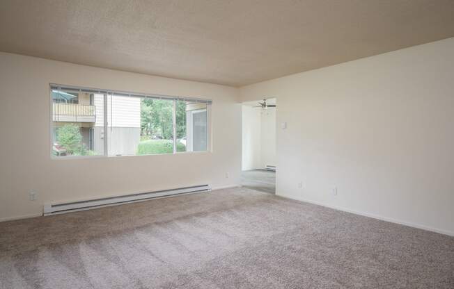 an empty living room with a large window