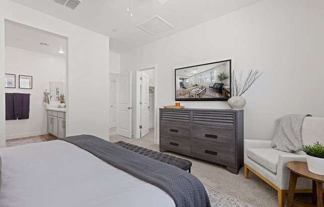 A bedroom with a large bed, a dresser, and a couch.