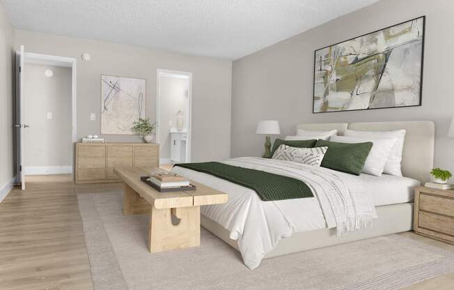 A bedroom with a large bed, a nightstand, and a wooden coffee table.