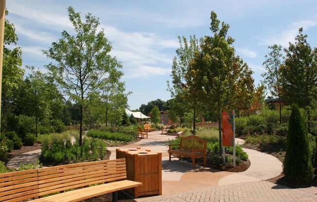 a park with benches and trees and a sign