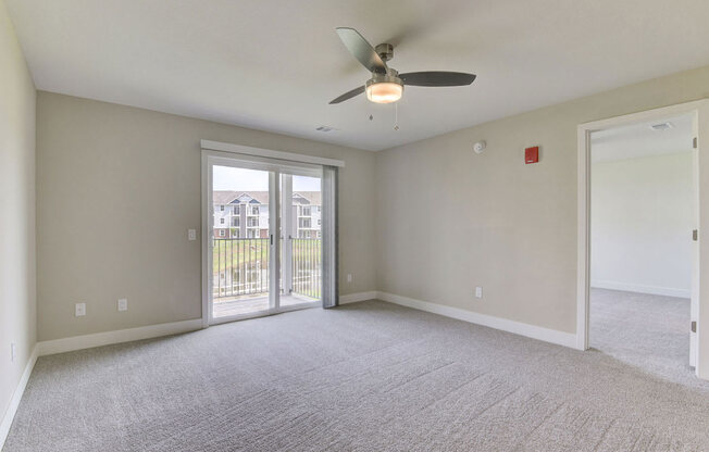 Two bedroom living room with a ceiling fan and a door to a balconyat Copper Creek Apartment Homes, Kansas, 67101