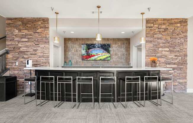 a bar with stools in a kitchen with stone walls