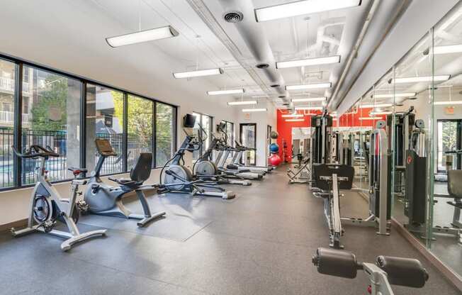 a gym with cardio equipment and windows in a building