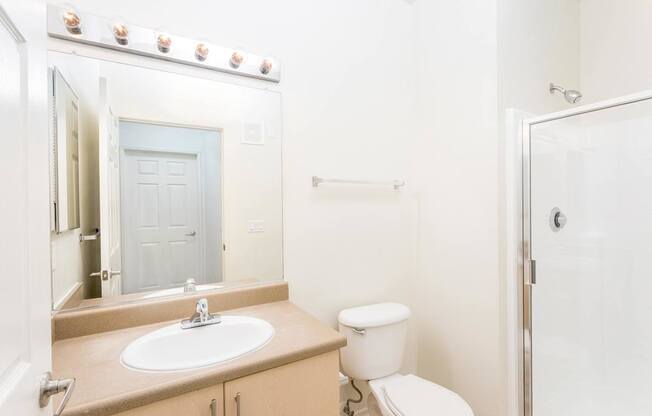 A bathroom with a sink, toilet, and shower. at La Jolla Crossroads Apartments, San Diego