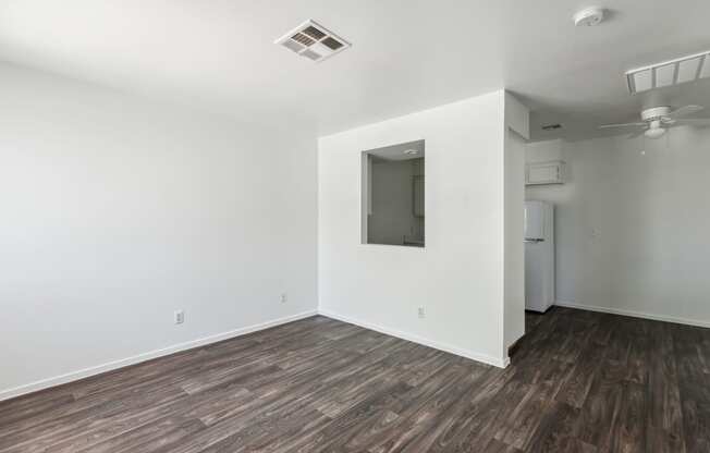 an empty living room with white walls and wood flooring