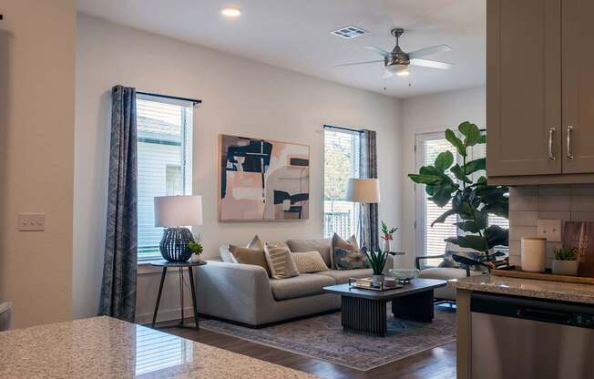 A living room with a couch, a table, and a painting on the wall.