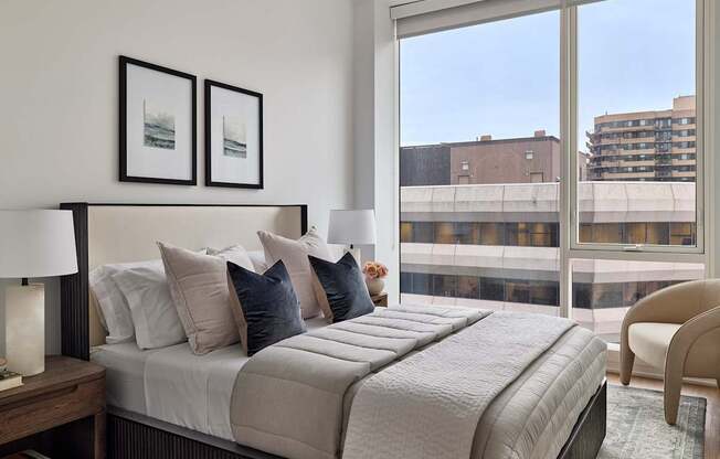 A bedroom with a large bed and a view of the city.