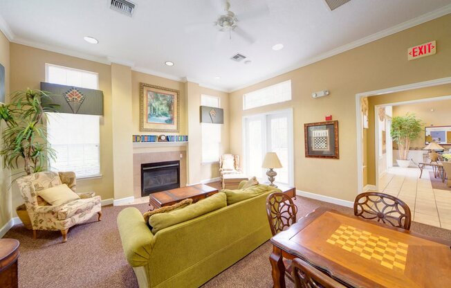 A living room with a green couch and a fireplace.