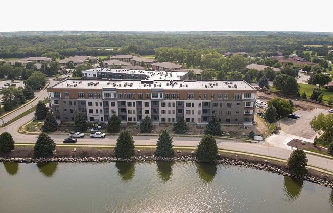 an aerial view of a building next to a lake