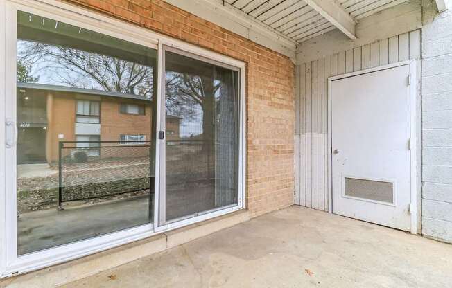 the patio of a building with sliding glass doors and a fence