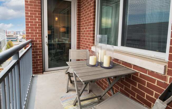 a patio with a wooden table and two candles on it