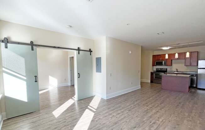 an open living room and kitchen area with a sliding barn door