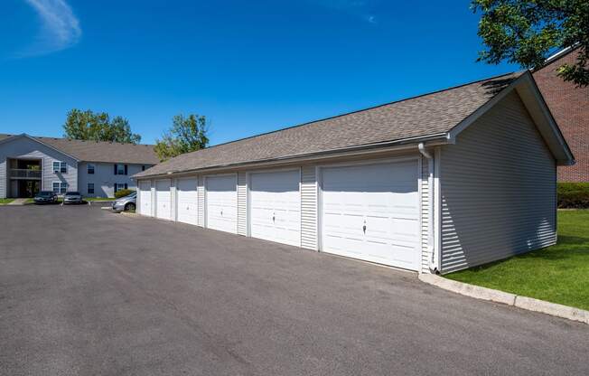 a white garage with white doors on the side of a driveway