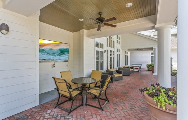 A patio with a table and chairs and a ceiling fan.at Century Hampton Roads, Virginia, 23435